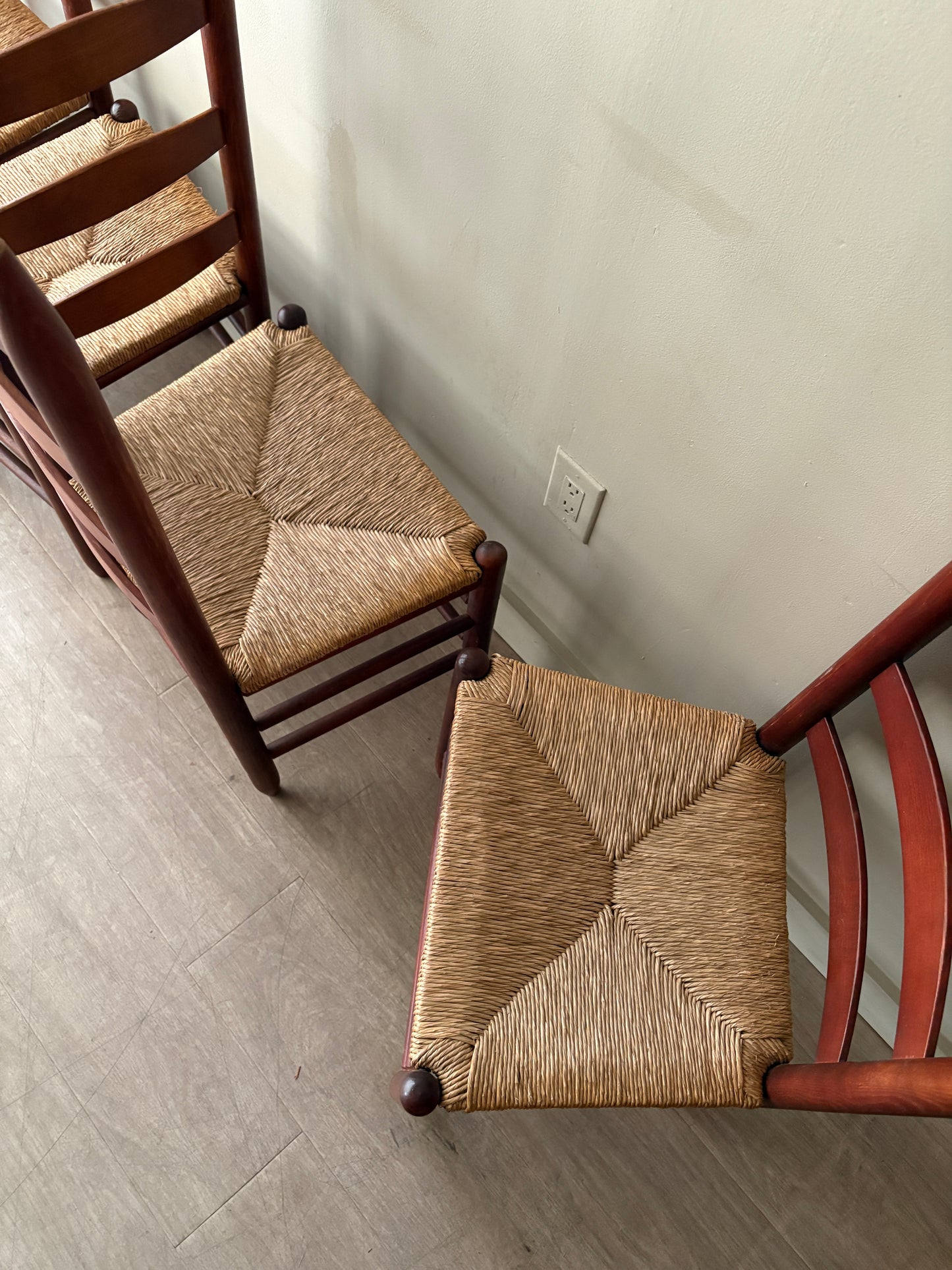 Stained oak rush seat ladder back dining chairs. Sold as a set of 4.