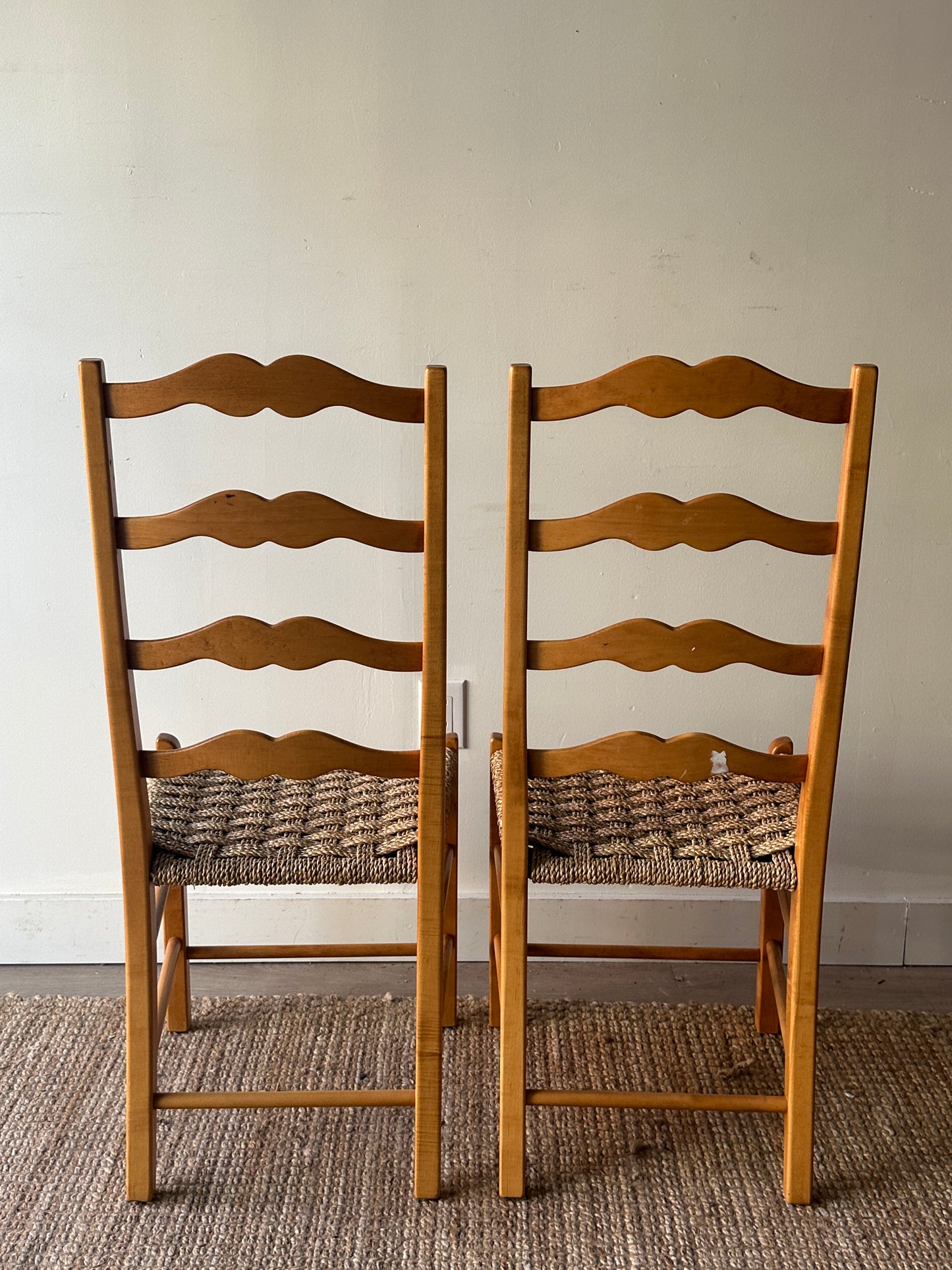 Ladder back chairs with woven seats. Sold as a pair.