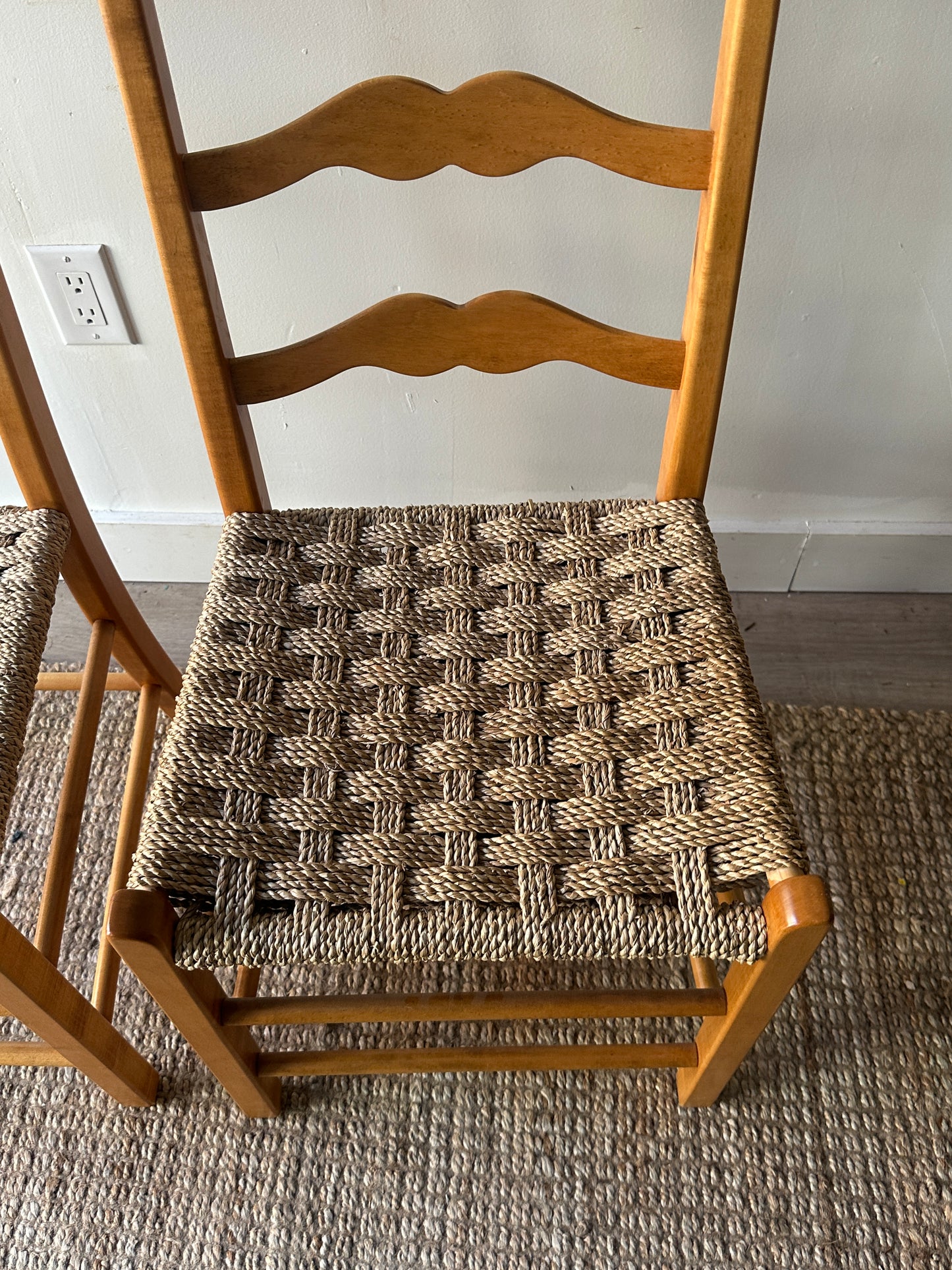 Ladder back chairs with woven seats. Sold as a pair.