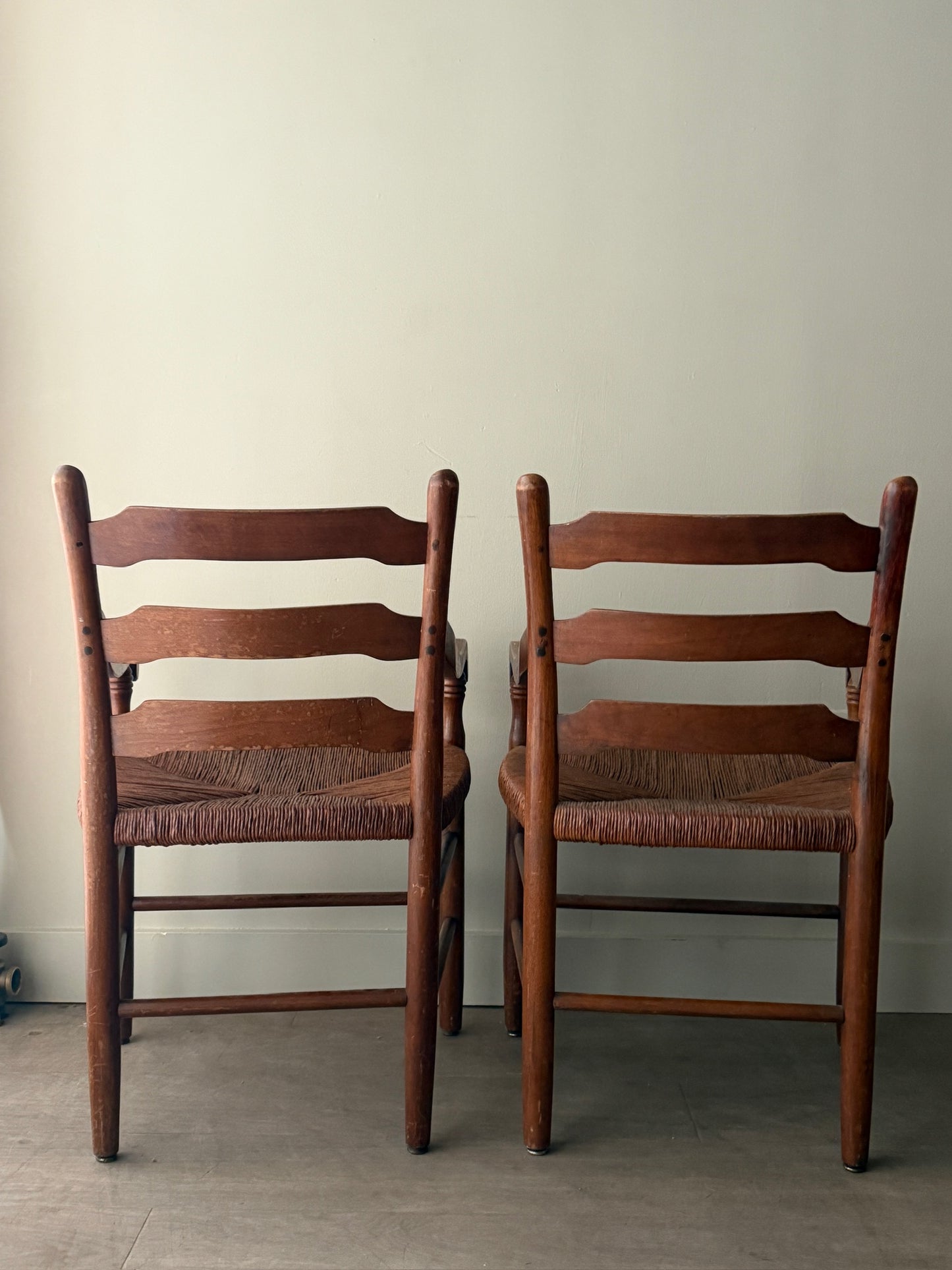 Ladder back rush seat pine arm chairs. Sold individually.