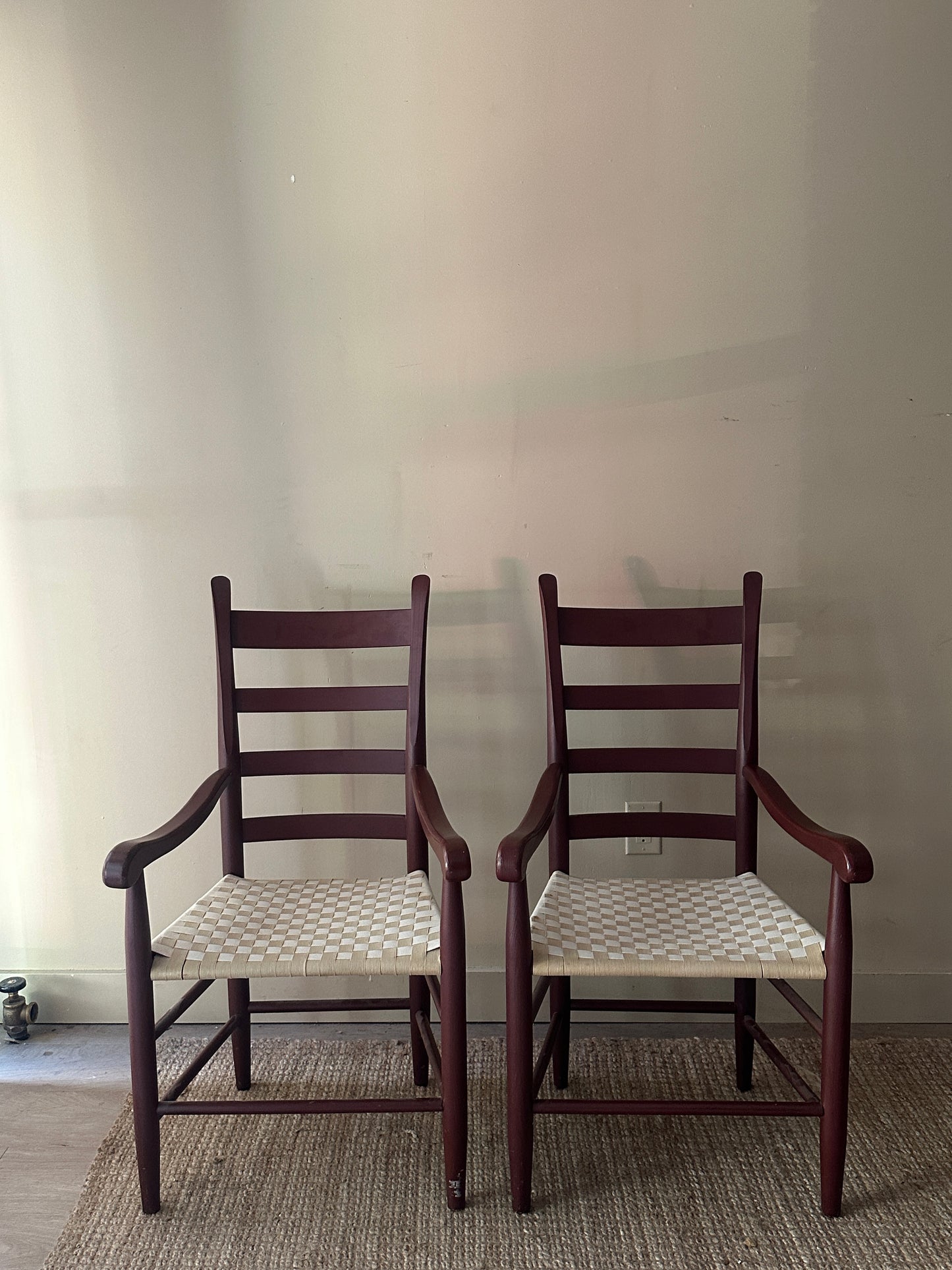 Woven chairs with arms. Sold as a pair.