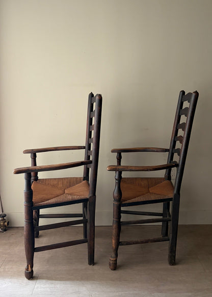 English provincial elmwood ladder back rush seat armchairs. Sold individually.