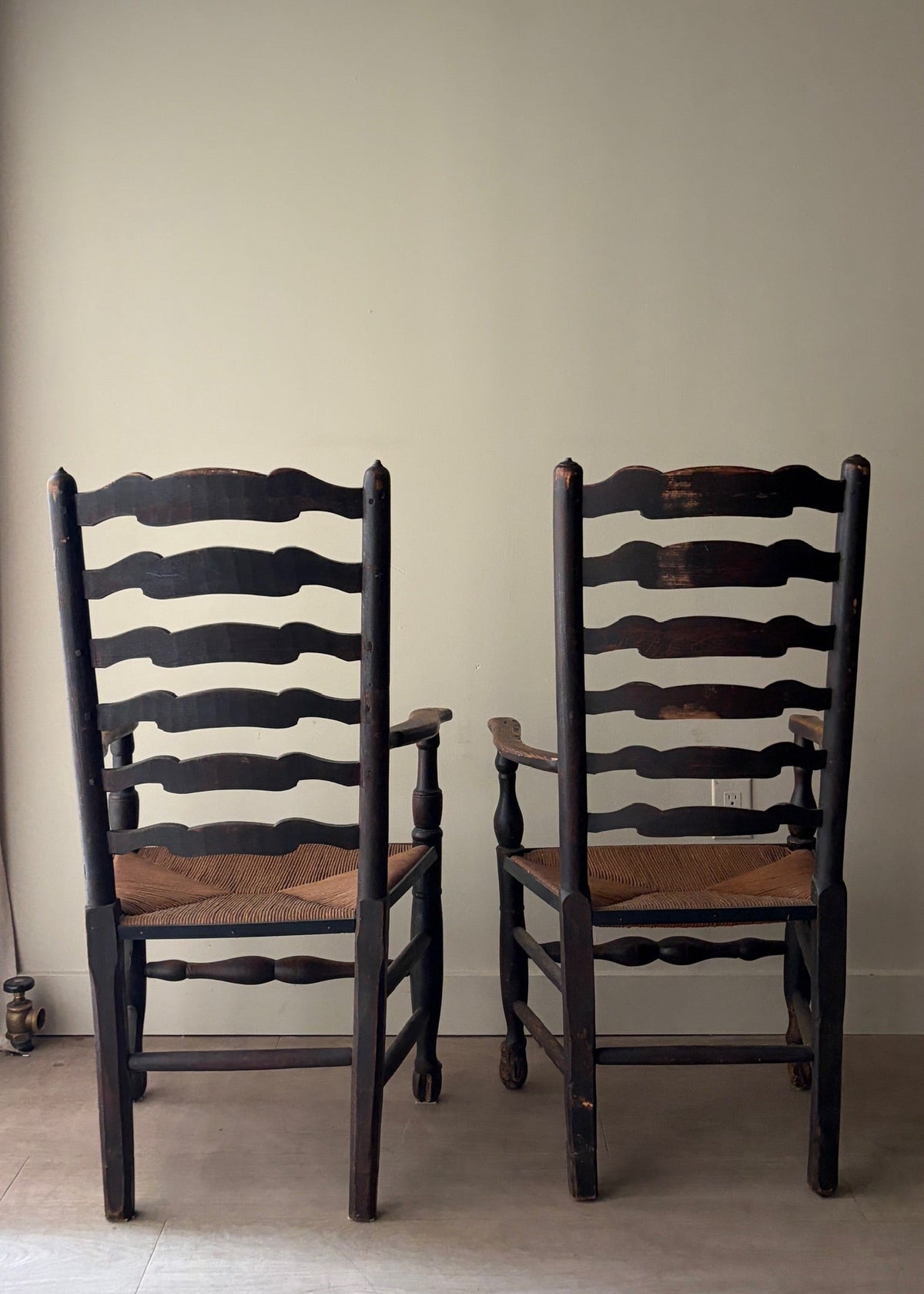 English provincial elmwood ladder back rush seat armchairs. Sold individually.