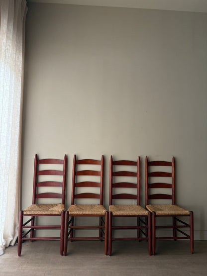 Stained oak rush seat ladder back dining chairs. Sold as a set of 4.