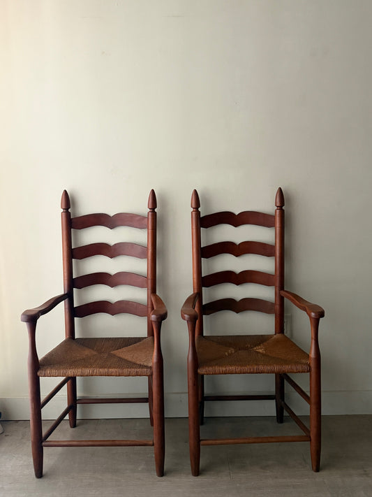 Cherry ladder back rush seat chairs with arms. Sold individually.