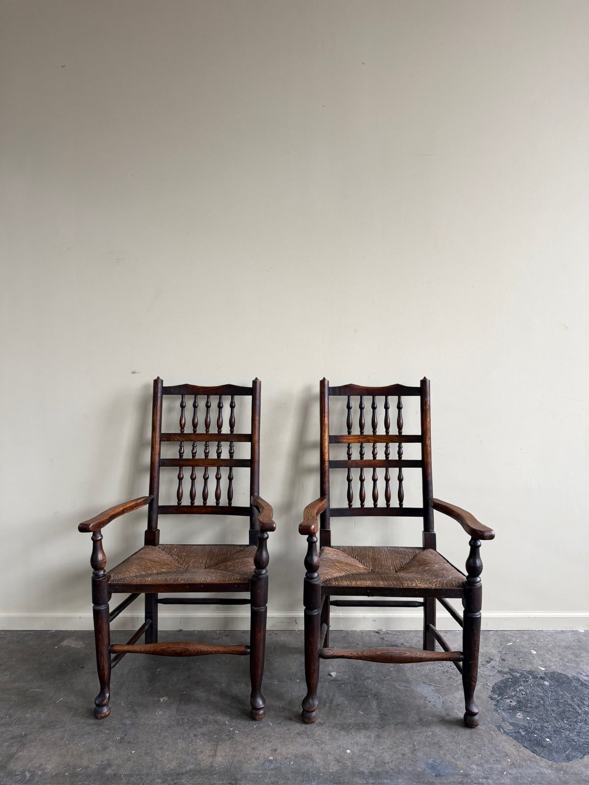 Dutch oak spindle back rush seat armchairs. Sold individually.