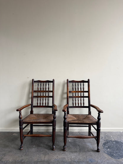 Dutch oak spindle back rush seat armchairs. Sold individually.
