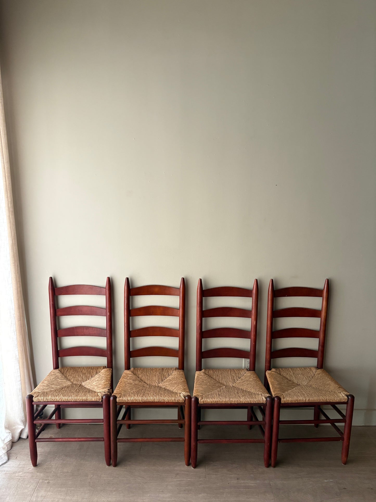 Stained oak rush seat ladder back dining chairs. Sold as a set of 4.