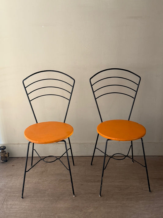 Metal wire chairs with orange seats. Sold as a pair.