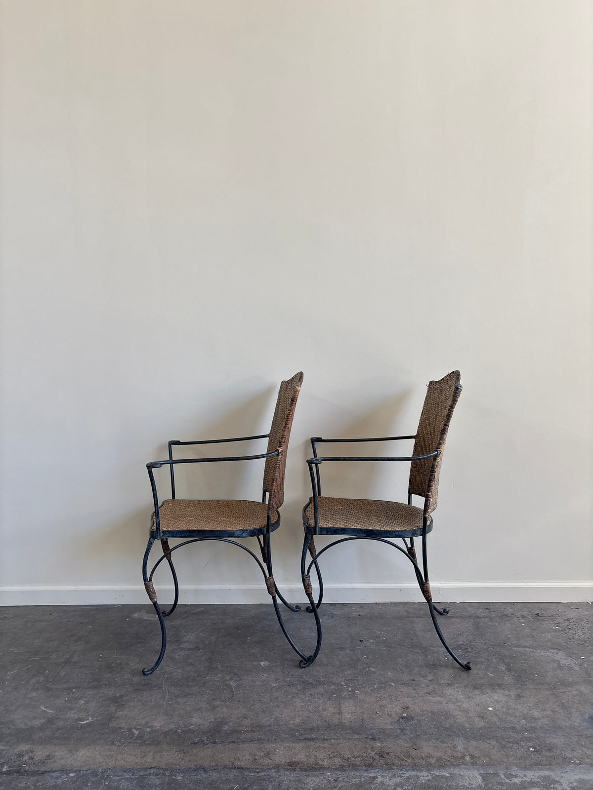 Wrought iron armchairs with woven bamboo backs & seats. Sold individually.
