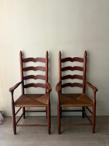 Cherry ladder back rush seat chairs with arms. Sold individually.
