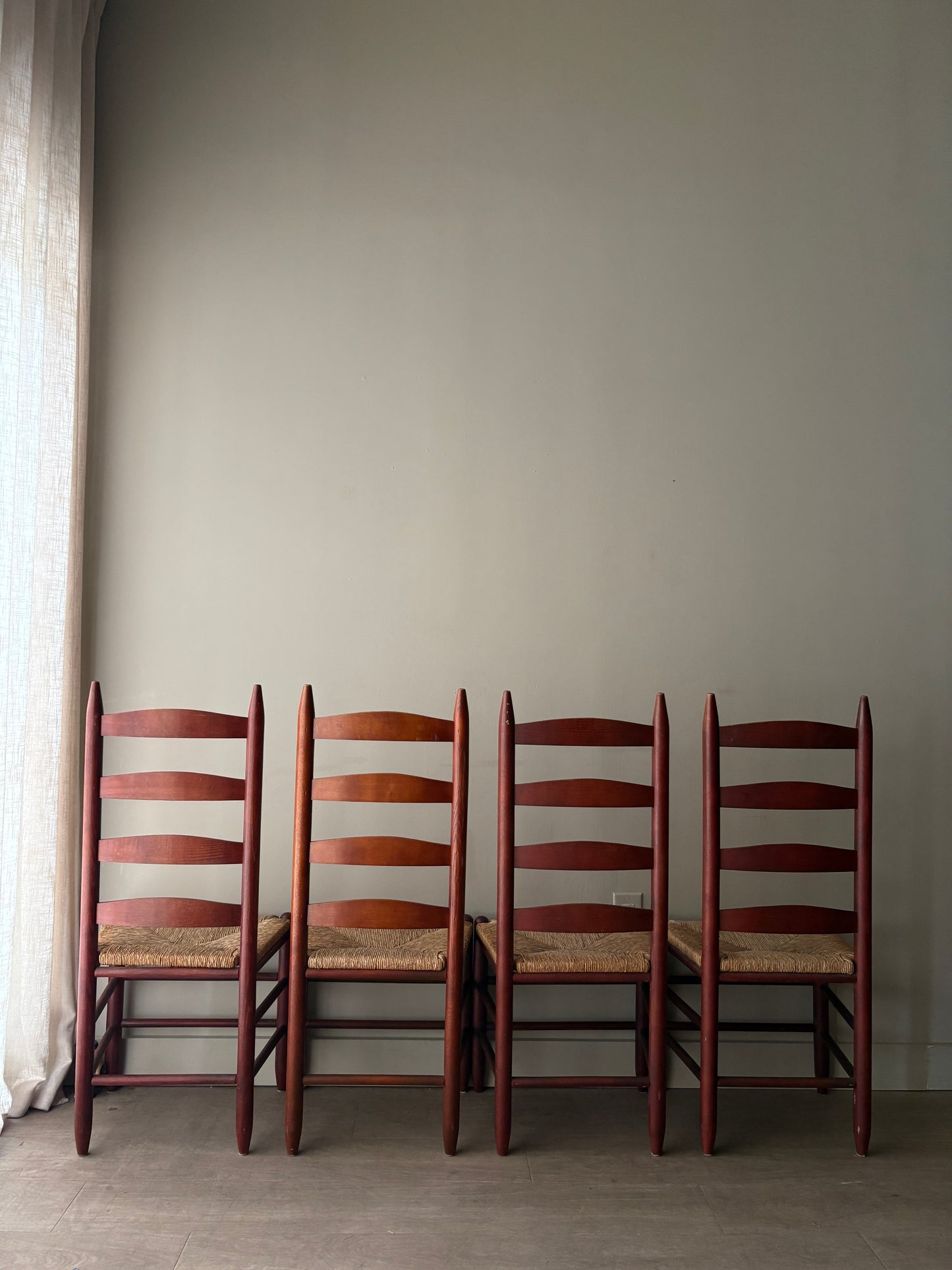 Stained oak rush seat ladder back dining chairs. Sold as a set of 4.