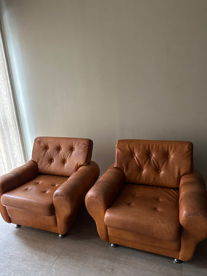 2 brown leather lounge chairs