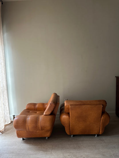 2 brown leather lounge chairs