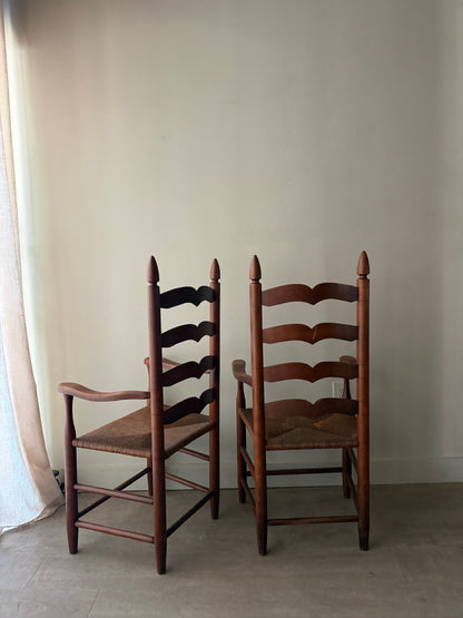 Cherry ladder back rush seat chairs with arms. Sold individually.