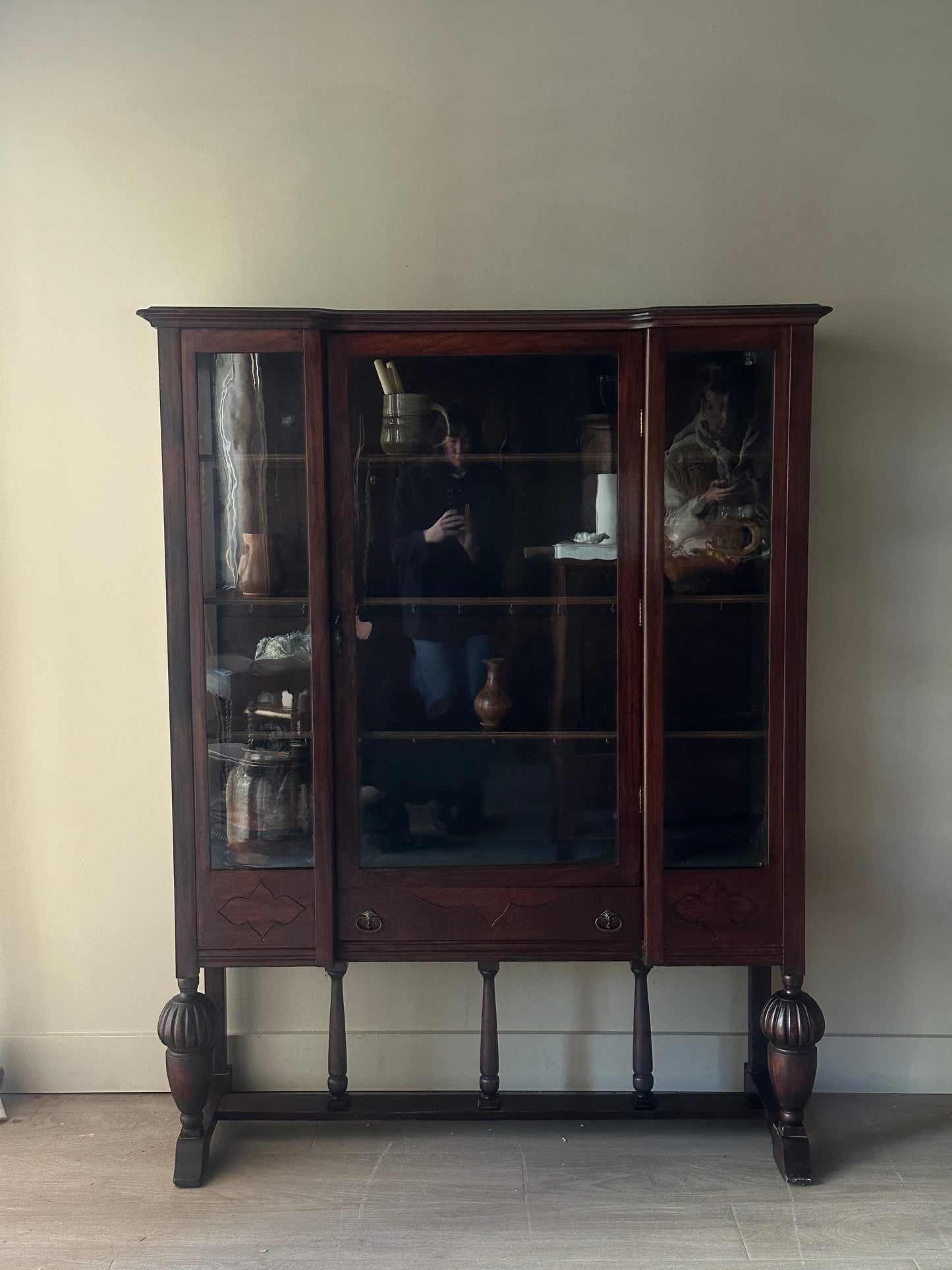 Glass display case with carved base