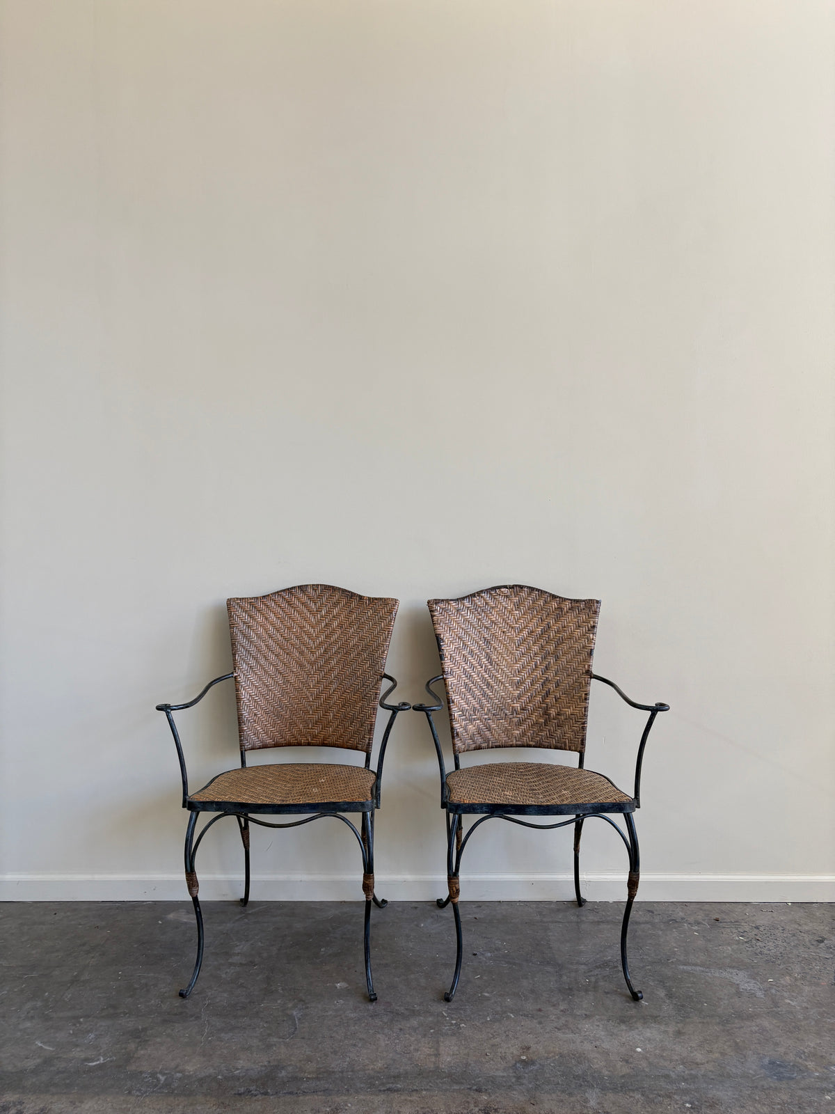 Wrought iron armchairs with woven bamboo backs & seats. Sold individually.