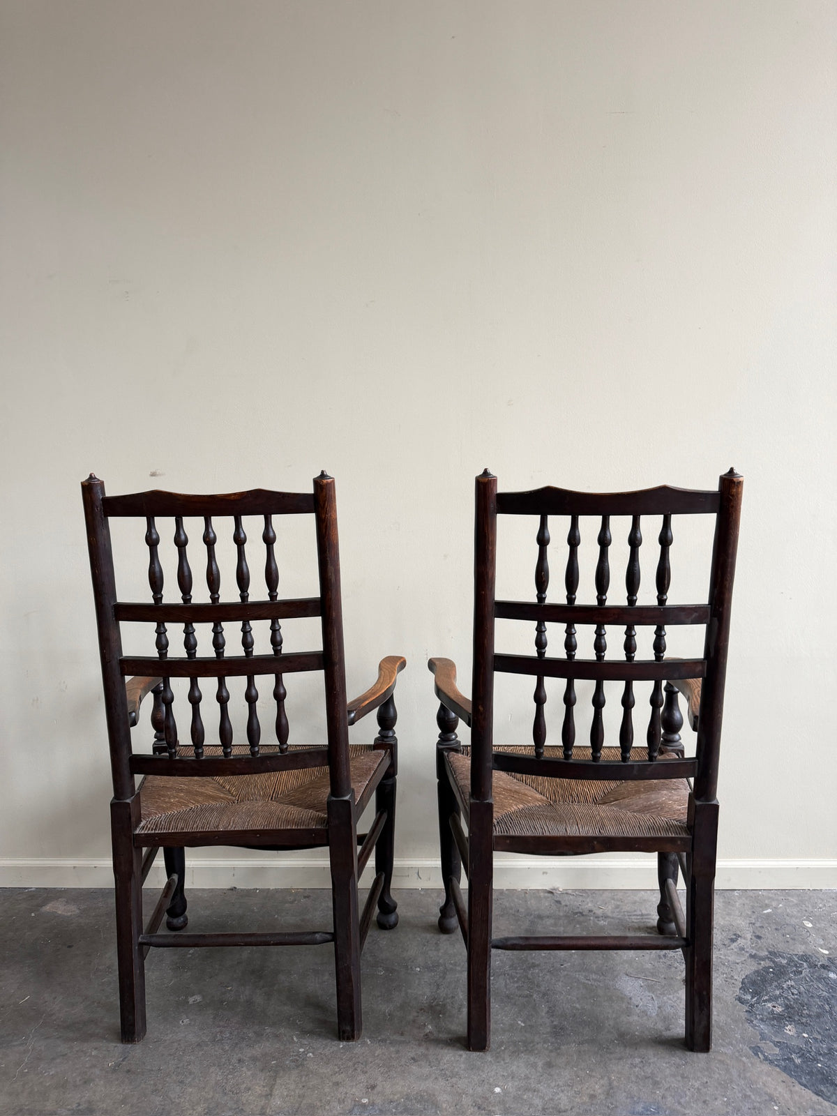 Dutch oak spindle back rush seat armchairs. Sold individually.