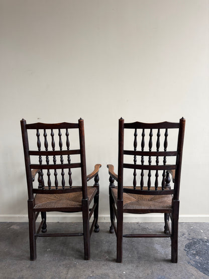 Dutch oak spindle back rush seat armchairs. Sold individually.