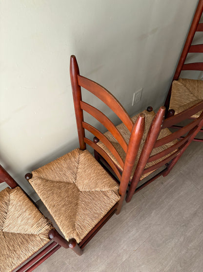 Stained oak rush seat ladder back dining chairs. Sold as a set of 4.