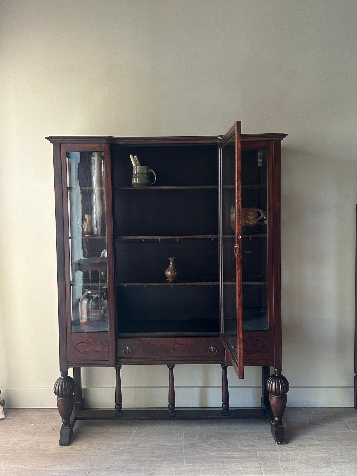Glass display case with carved base