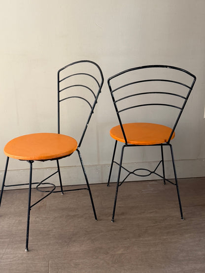 Metal wire chairs with orange seats. Sold as a pair.