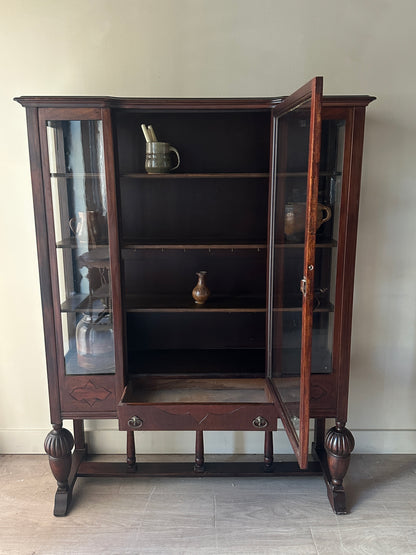 Glass display case with carved base