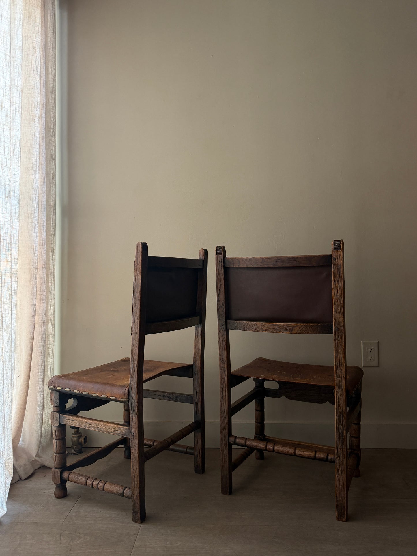 Spanish leather and oak chairs. Sold individually.