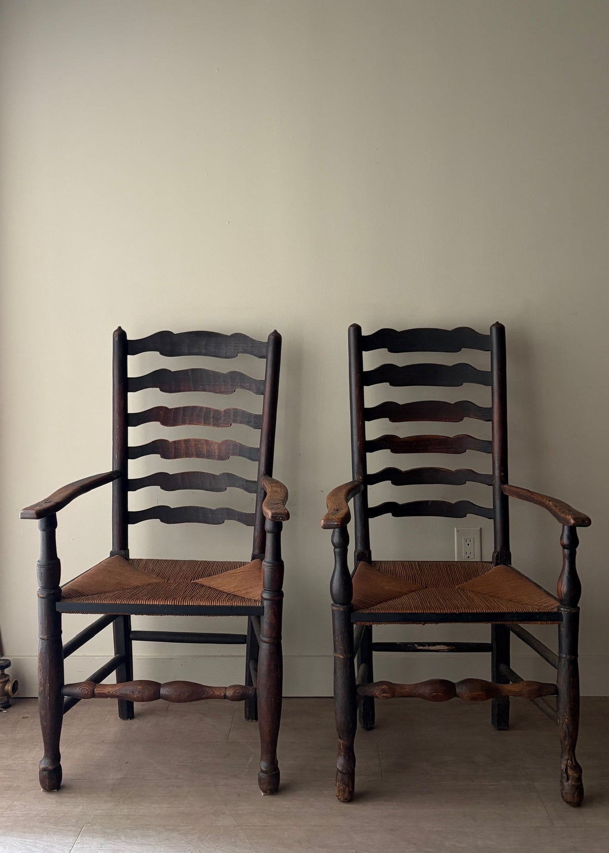 English provincial elmwood ladder back rush seat armchairs. Sold individually.