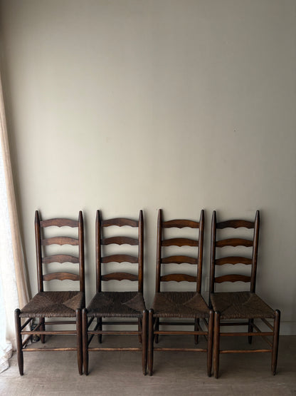 Stained oak rush seat ladder back dining chairs. Sold in pairs.