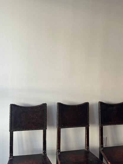 Leather and walnut nailhead dining chairs. Sold individually.