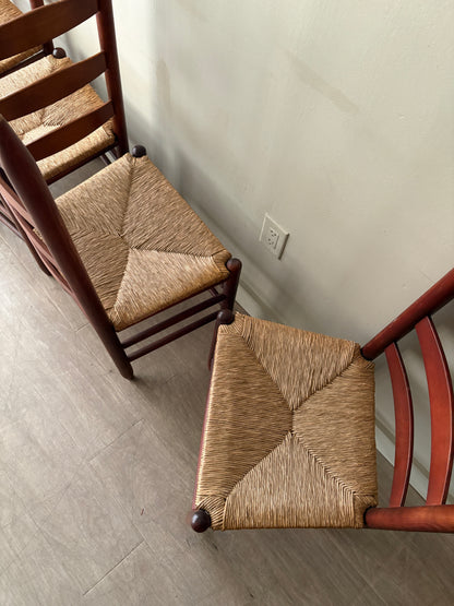 Stained oak rush seat ladder back dining chairs. Sold as a set of 4.