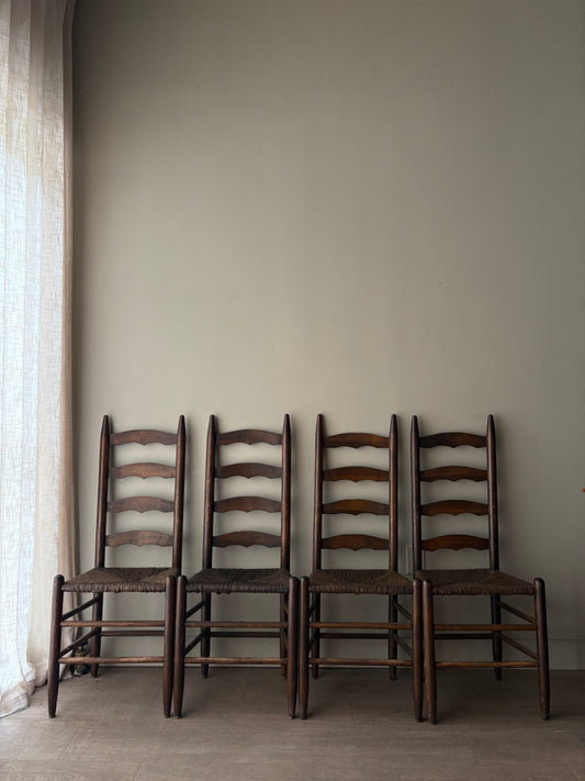 Stained oak rush seat ladder back dining chairs. Sold in pairs.