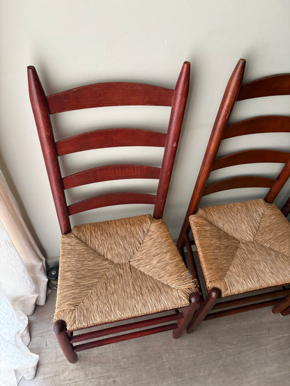 Stained oak rush seat ladder back dining chairs. Sold as a set of 4.