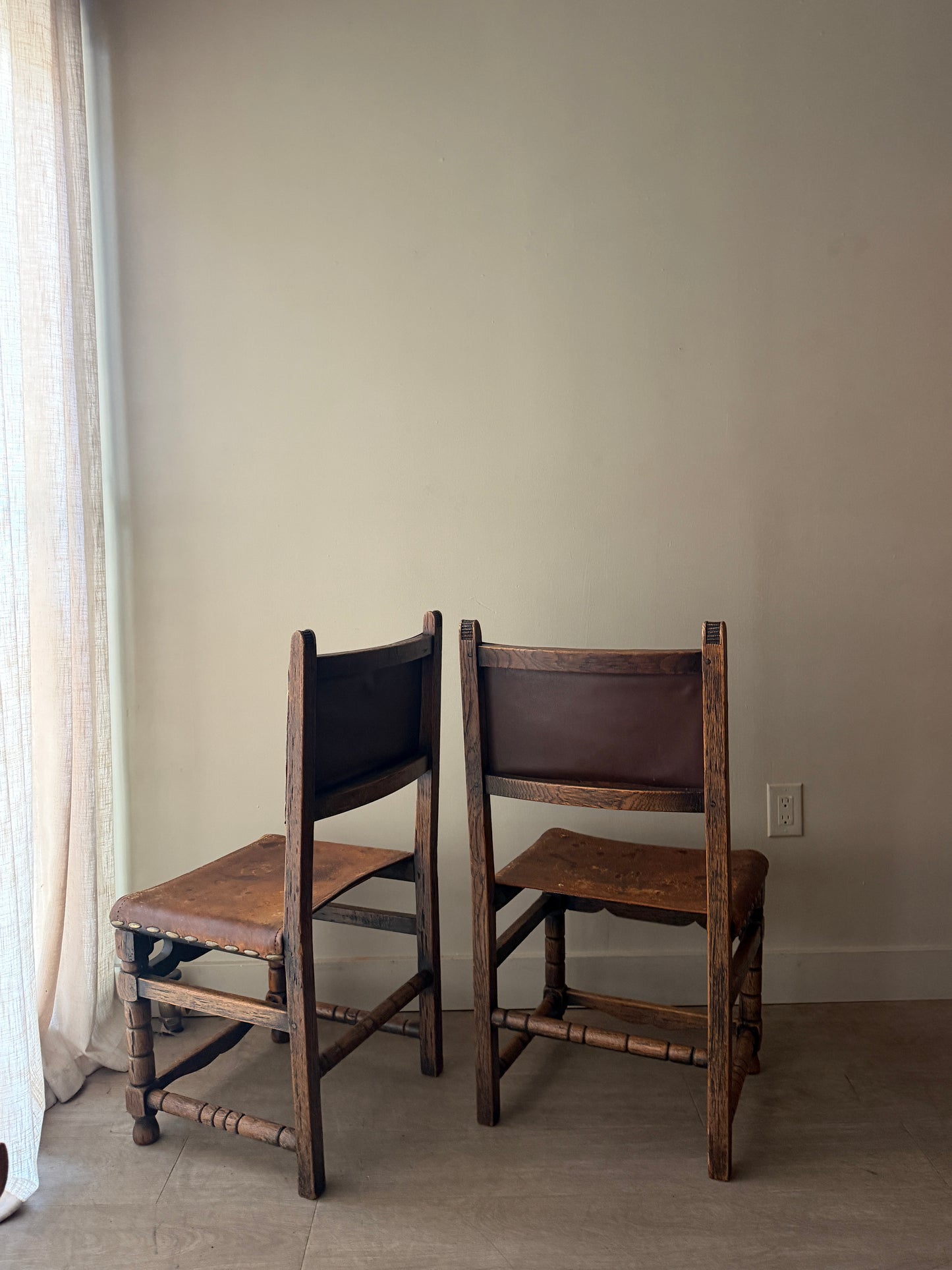Spanish leather and oak chairs. Sold individually.