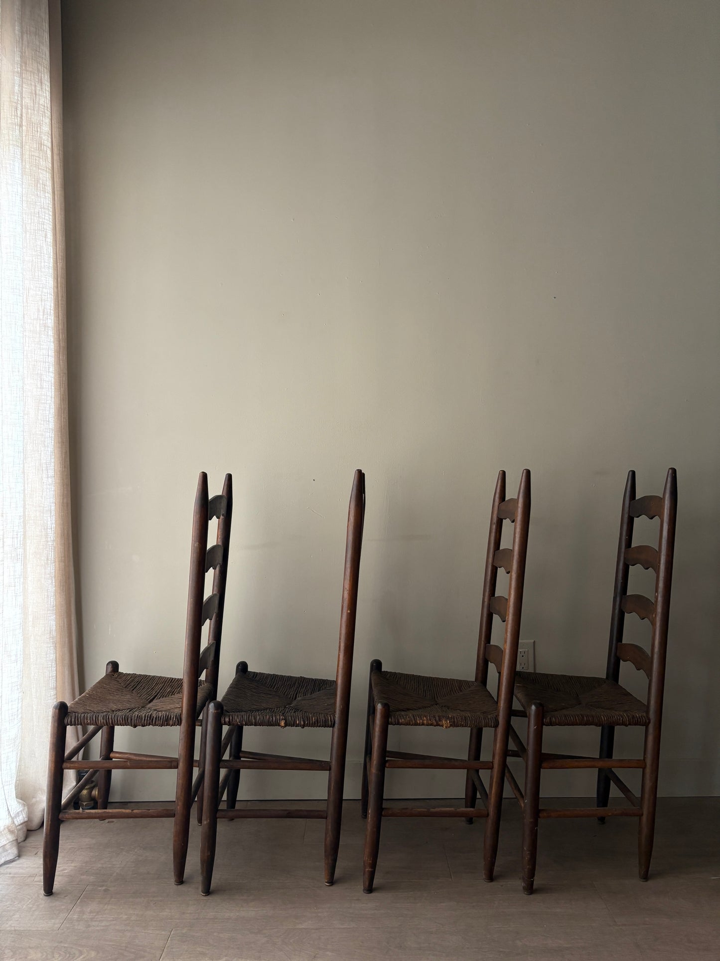 Stained oak rush seat ladder back dining chairs. Sold in pairs.
