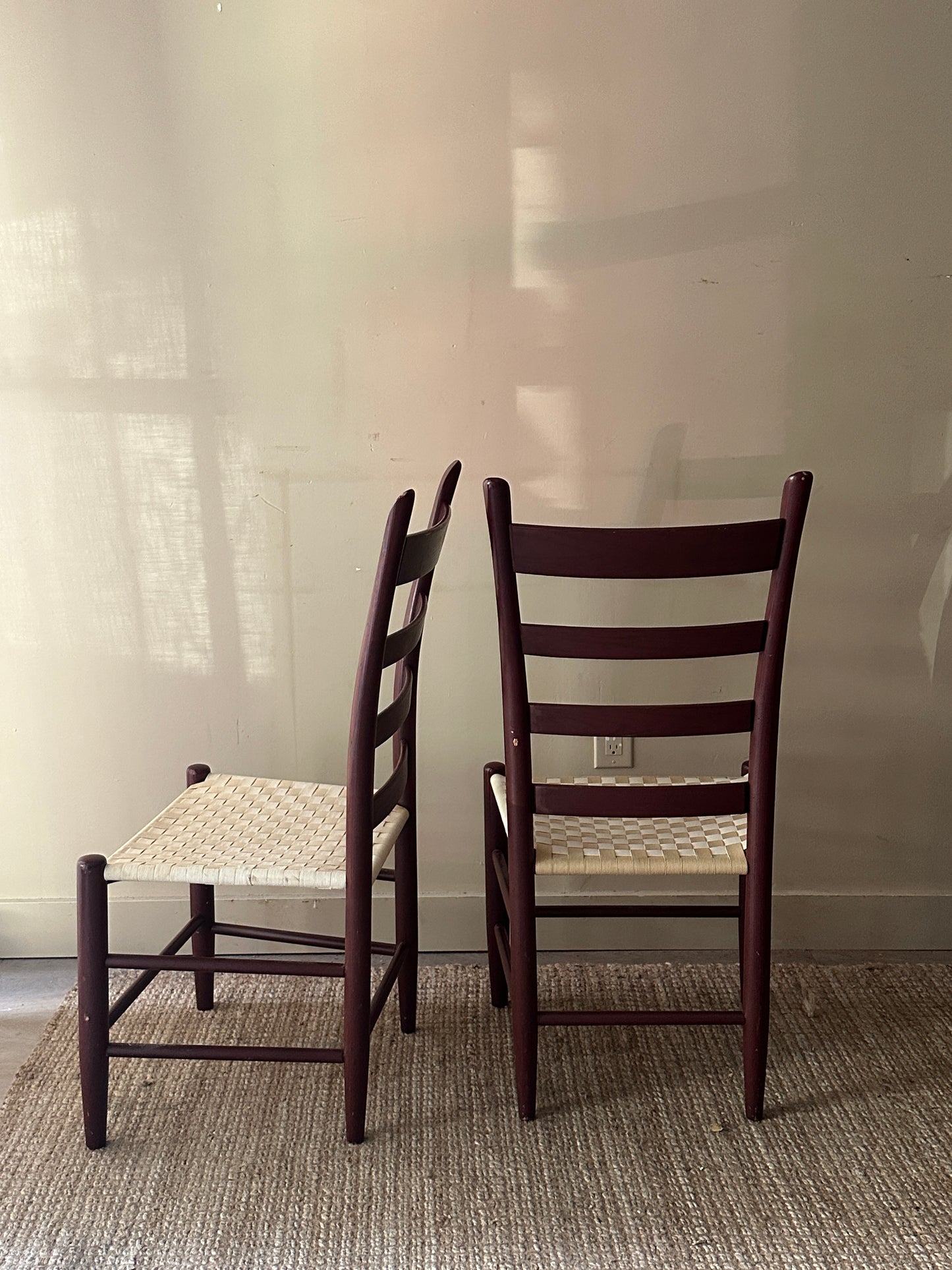 Armless woven chairs. Sold as a pair.