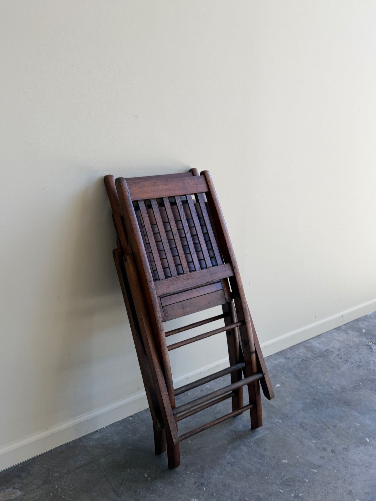 Stained pine folding chairs. Sold as a pair.