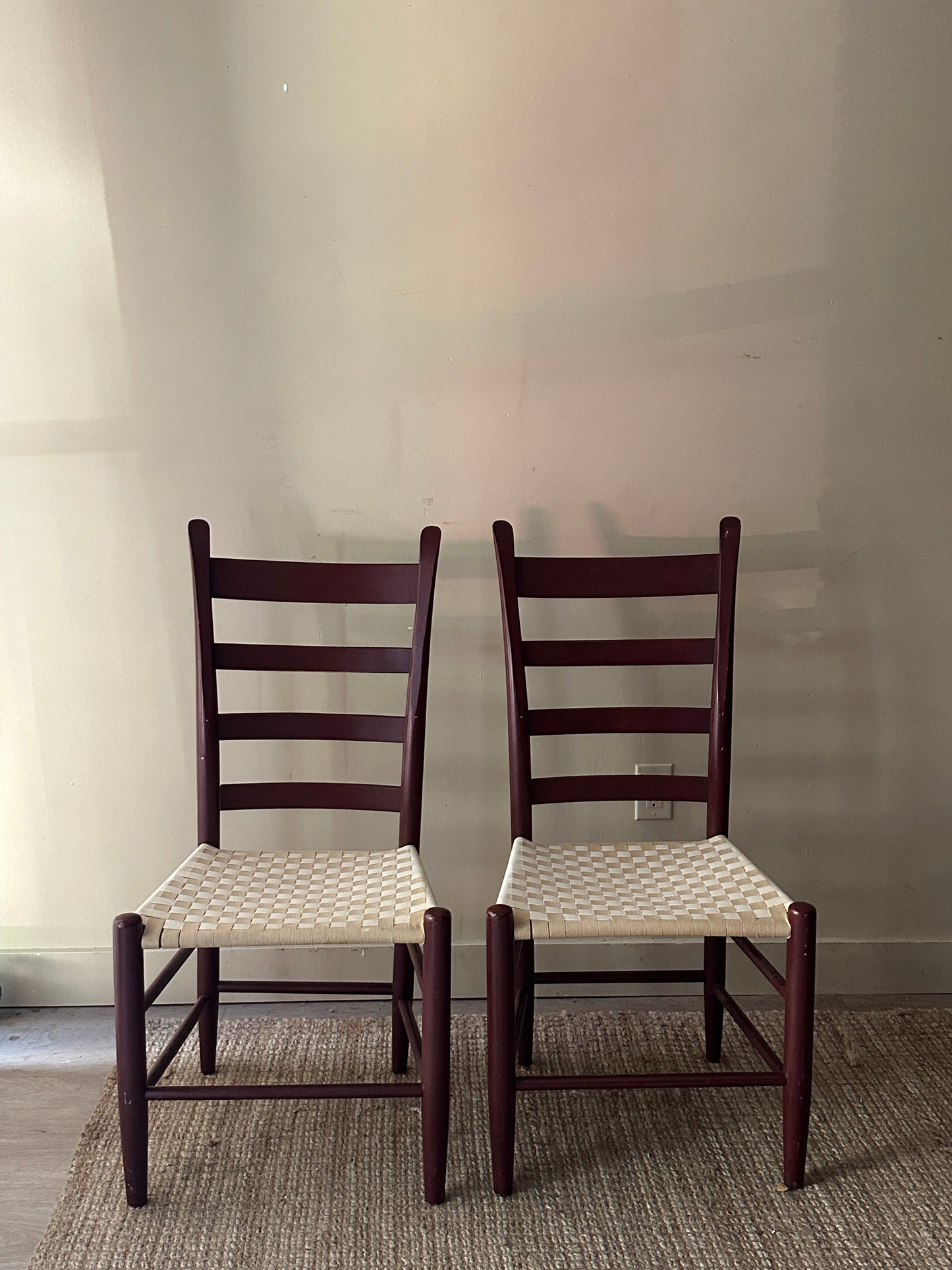 Armless woven chairs. Sold as a pair.