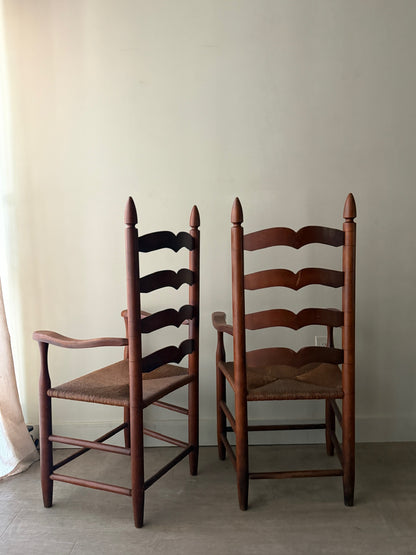 Cherry ladder back rush seat chairs with arms. Sold individually.