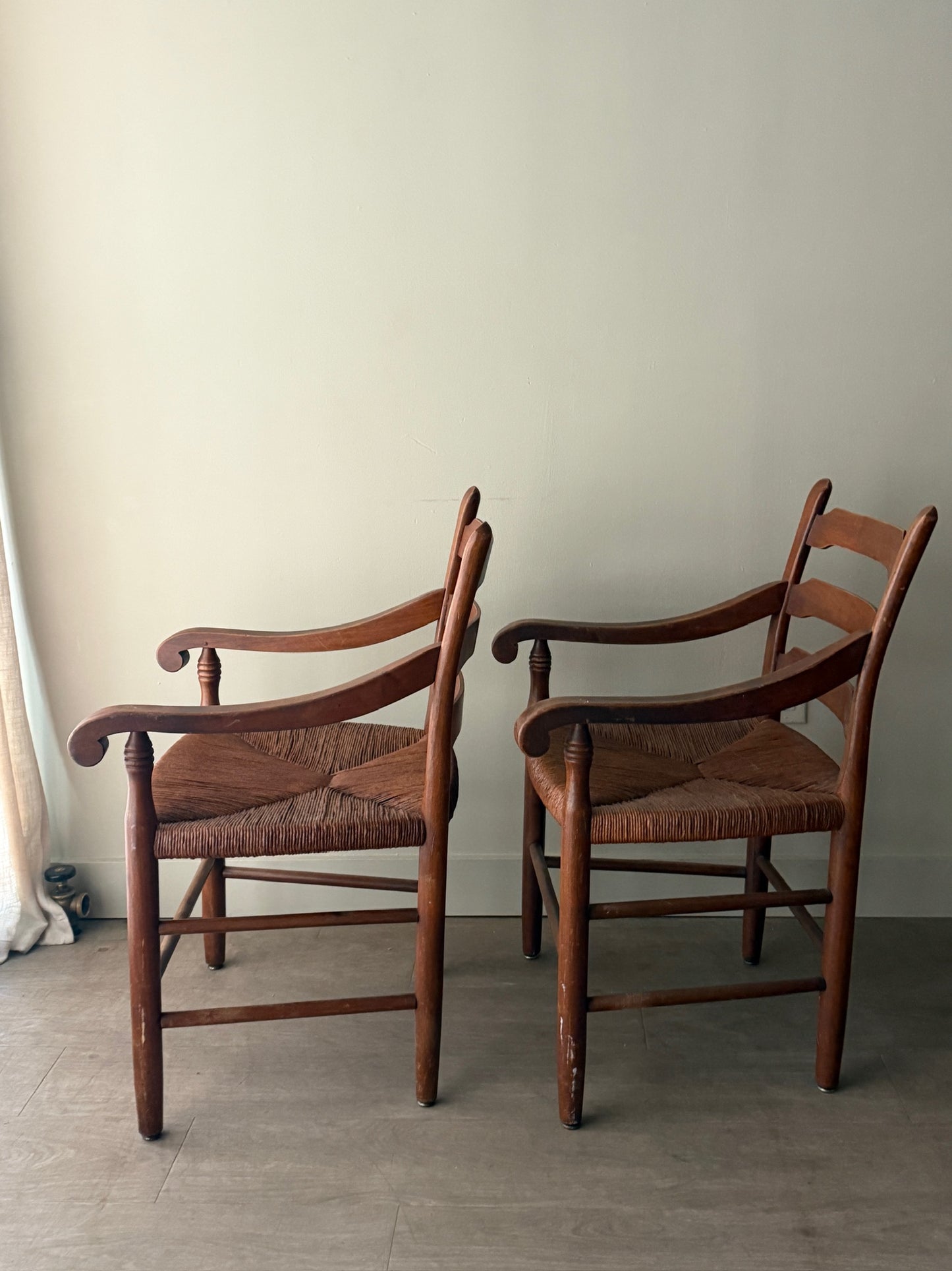 Ladder back rush seat pine arm chairs. Sold individually.