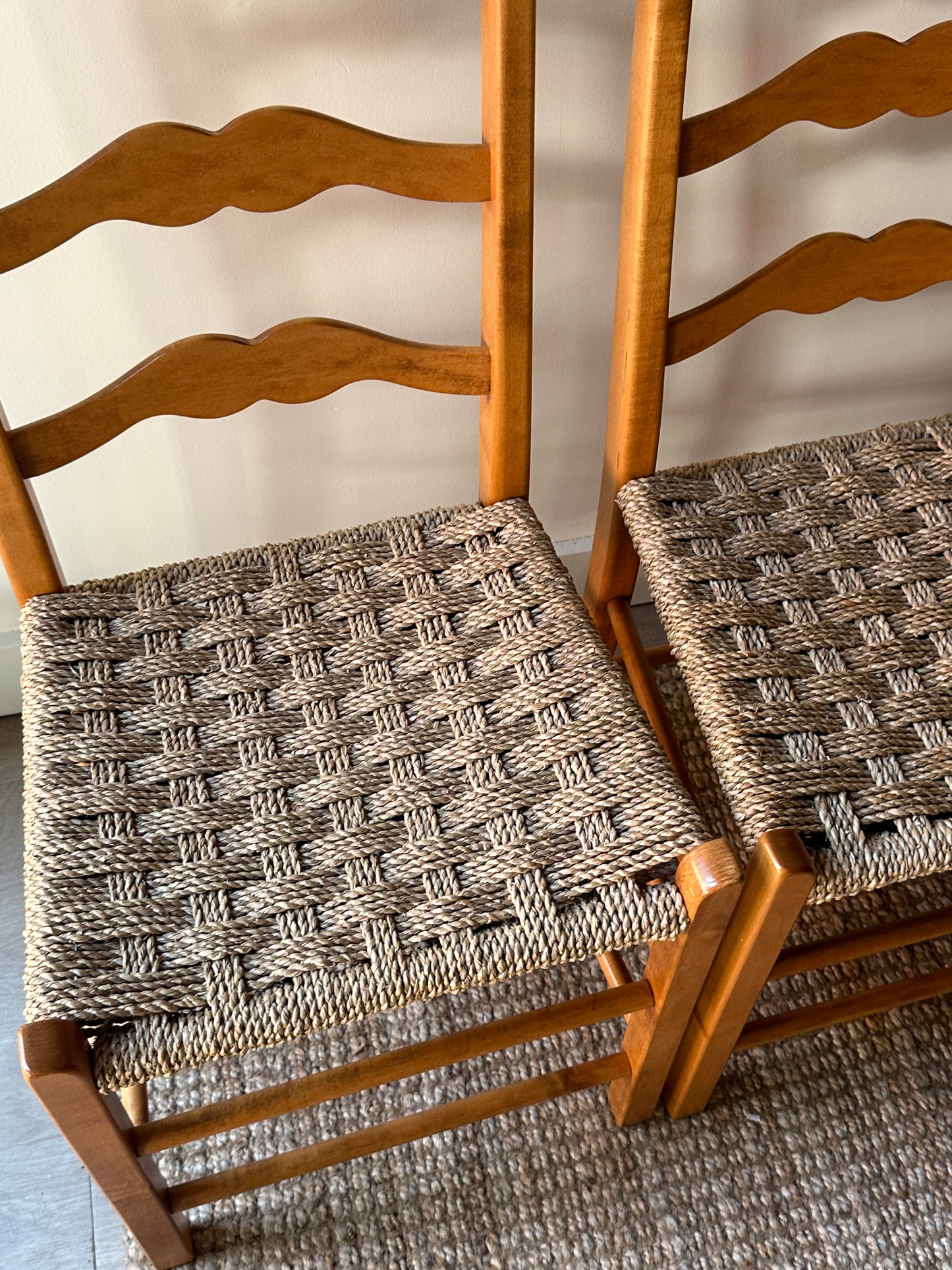 Ladder back chairs with woven seats. Sold in sets of 2.