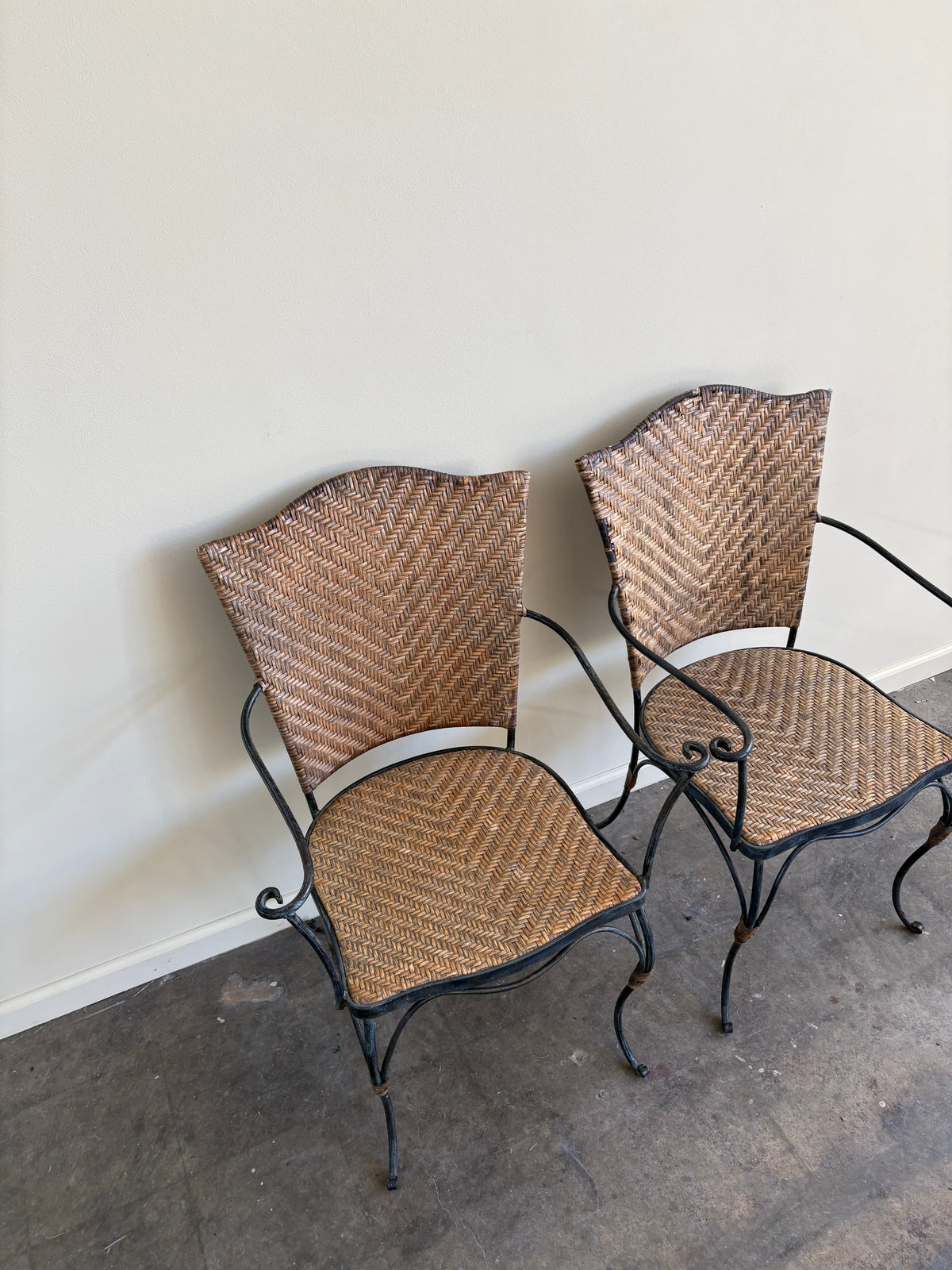 Wrought iron armchairs with woven bamboo backs & seats. Sold individually.