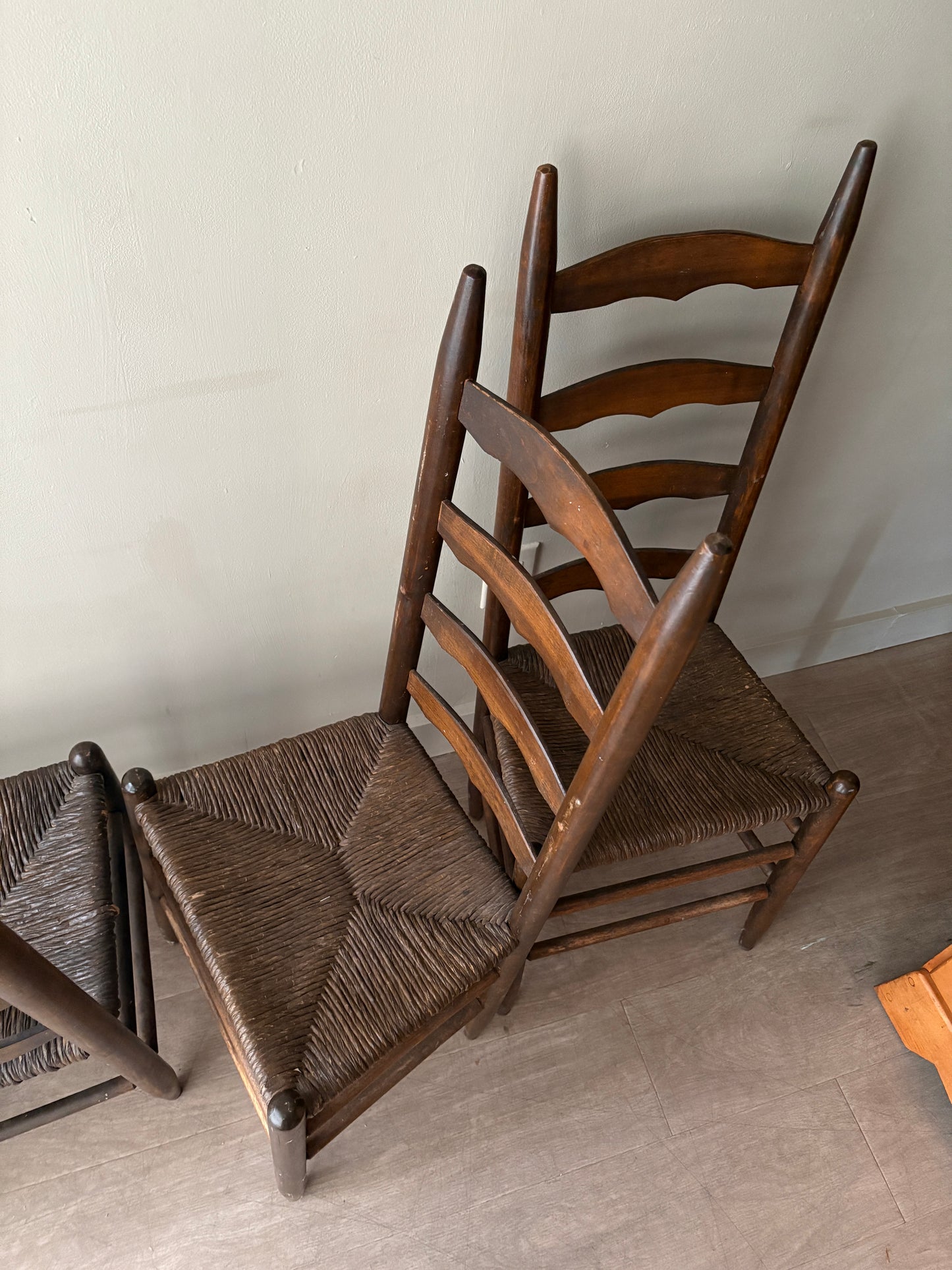 Stained oak rush seat ladder back dining chairs. Sold in pairs.