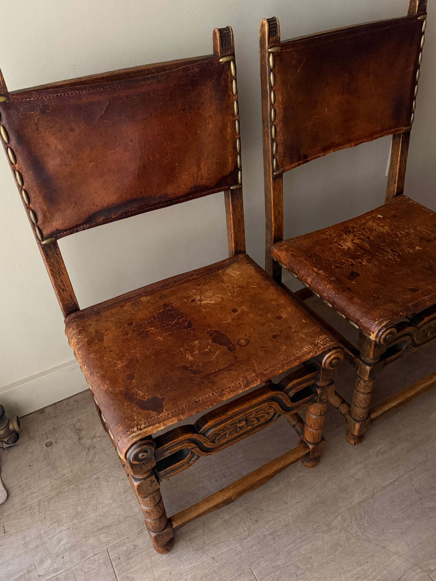 Spanish leather and oak chairs. Sold individually.