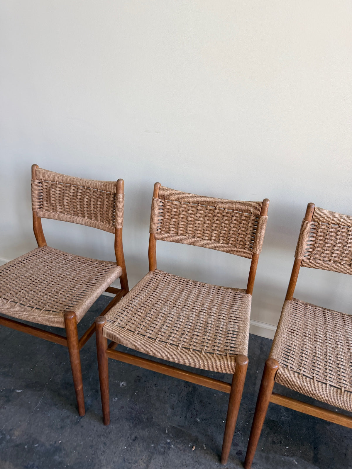 Danish oak and papercord chairs. Sold individually.